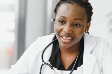 Closeup portrait of friendly, smiling confident female healthcare professional with lab coat, stethoscope, arms crossed. Isolated hospital clinic background. Time for an office visit