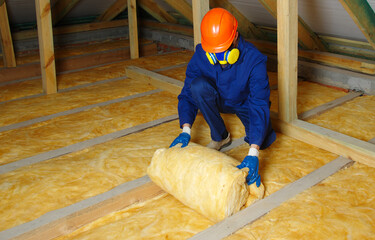 Wall Mural - Worker thermally insulating house attic with glass wool