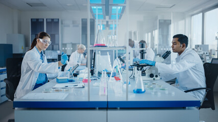 Wall Mural - modern medical research laboratory: diverse team of scientists working with pipette, analysing bioch