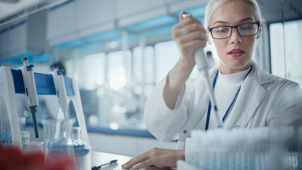 Wall Mural - medical research laboratory: portrait of a beautiful female scientist in goggles using micro pipette