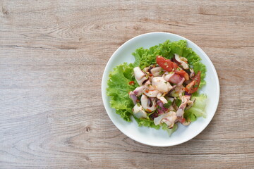  Thai spicy squid salad and fresh vegetable on plate