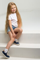 Wall Mural - Girl in casual clothes sitting on white staircase