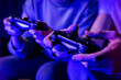 canvas print picture - friends playing console video games. controller in hands closeup. neon lights