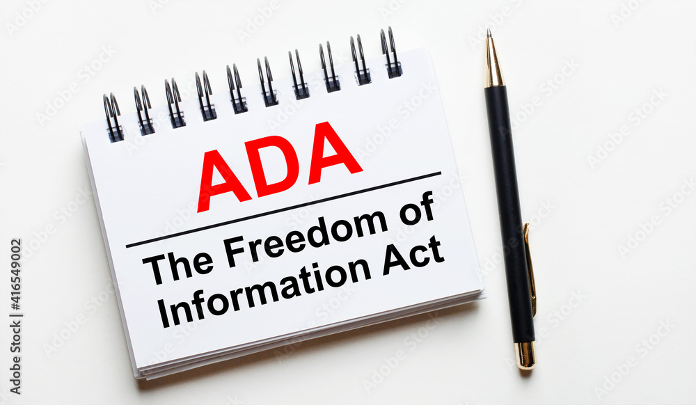 On a light background, a white notebook with the words ADA Americans ...