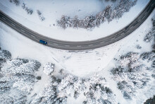 Car driving on bends on snowy mountain road from above, Switzerland, Europe