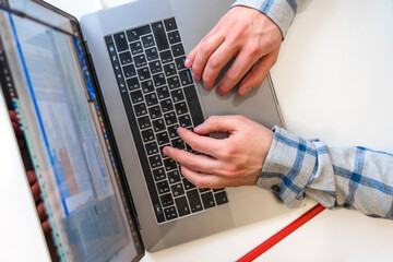 Canvas Print - men's hands typing on a laptop keyboard, a business concept of working in the office as a programmer