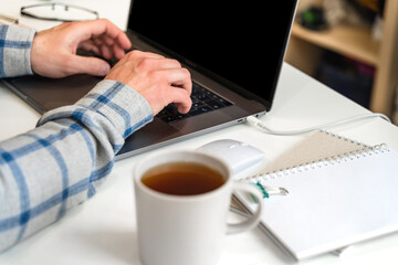 Canvas Print - men's hands typing on a laptop keyboard, a business concept of working in the office as a programmer
