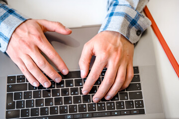 Canvas Print - men's hands typing on a laptop keyboard, a business concept of working in the office as a programmer