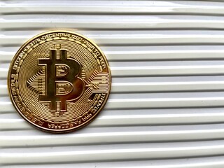 Golden bitcoin coin on silver metal background, bitcoin is most popular crypto currency with copy space