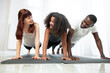 © sofiko14 - Happy multiracial family, father, mother and teen daughter, doing push up or press up exercise at cozy light home interior. Pastime with kid concept