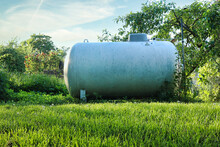 Backyard Propane Tank Surrounded By Green Trees And Grass On A Warm Spring Evening In Potzbach, Germany.