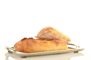 Two delicious freshly baked French baguettes on a metal tray, close-up, isolated on white.