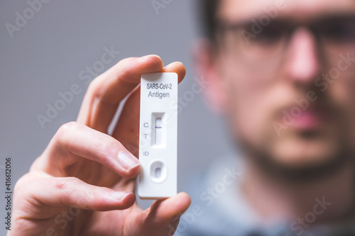 Express corona test at home: Close up of young man holding a negative covid antigen test © Patrick Daxenbichler