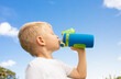 © kieferpix - little boy drinking from bottle of water outdoors. Health and body care concept.