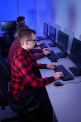 a group of young programmers work in an office at a computer and type text on the keyboard. the blue