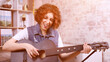 a girl musician with curly hair sings a song with a guitar