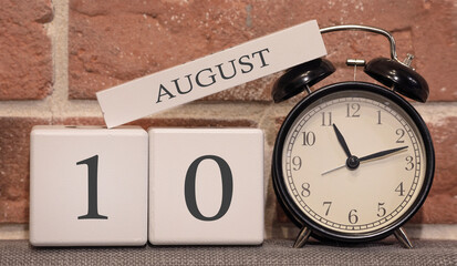 Wall Mural - Important date, August 10, summer season. Calendar made of wood on a background of a brick wall. Retro alarm clock as a time management concept.