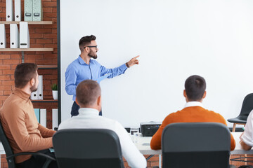 Canvas Print - Businessman giving presentation during meeting in office