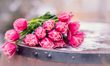 Bouquet Of Tulips On A Wooden Barrel. An Armful Of Pink Flowers Lie On The Table. Spring Concept. Copy Space. Composition For Women's Day March 8, Mother's Day.