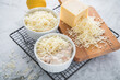 Typisches DDR Würzfleisch Ragout Fin mit geriebenen Gouda Käse in Auflaufform Schale und Zitrone auf Abkühlgitter und Marmor Hintergrund hell
