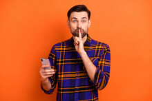 Photo Of Handsome Guy Finger Covering Mouth Lips Do Not Talk Look Camera Isolated On Orange Color Background
