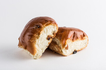 Two sweet buns with raisins on a white background, isolated. Close-up with a copy space for the text.