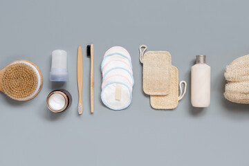 Top view of different hygiene and beauty items on grey background.