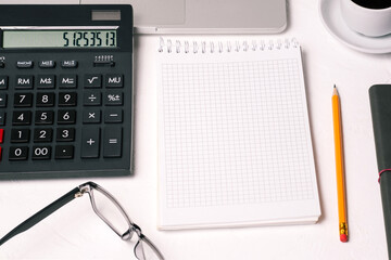 Company employee work desk with calculator, computer and notepad with blank paper for text. Accounting, data analysis and reporting. Work at home or in the office. Business concept