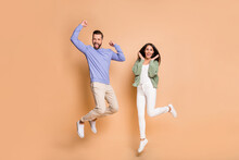 Full Length Body Size View Of Nice Cheerful Lucky Partners Couple Jumping Having Fun Isolated On Beige Pastel Color Background