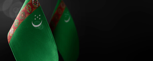 Small national flags of the Turkmenistan on a dark background