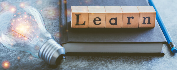 Wall Mural - Cube letter word of Learn with textbook and light bulb. Self learning or education knowledge and business studying concept