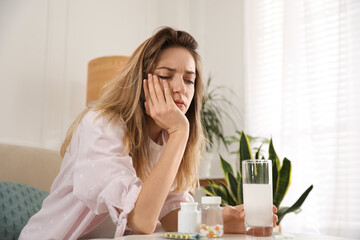 Wall Mural - Woman holding glass of medicine for hangover at home