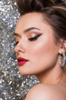 © romanovad - Beautiful brunette woman with perfect evening makeup holding disco mirror balls. Red lips and perfect skin. New year or birthday party concept