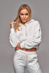 Wall Mural - Beautiful sexy blonde woman wear of white set of tracksuit isolated on gray background