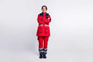 Poster - Full length photo of good mood young ambulance lady dressed red uniform hands folded smiling isolated white color background