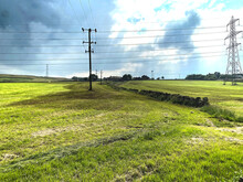 Farmland, With A Dry Stone Wall, Electric Pylons, Seagulls, And Rain Clouds Above In, Thornton, Bradford, UK