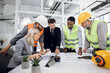 © sofiko14 - Diverse group of specialists working with blueprints