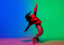 Inspiration. Stylish Sportive Girl Dancing Hip-hop In Stylish Clothes On Colorful Background At Dance Hall In Neon Light. Youth Culture, Movement, Style And Fashion, Action. Fashionable Bright