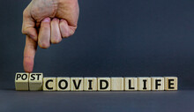 Symbol for a post-covid life. Businessman turns cubes and changes words 'covid life' to 'post-covid life'. Beautiful grey background. Medical, business and covid-19 pandemic concept, copy space.