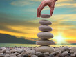 © daphnusia - The man's hand is putting gravel on the stone tower. Personal Development Concept