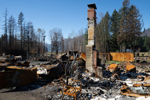 Home In Detroit Oregon Totally Destroyed By The Beachie Creek Wildfire.  Chimney And Fireplace All That Remain.  Burned Trees On Mountain In Background