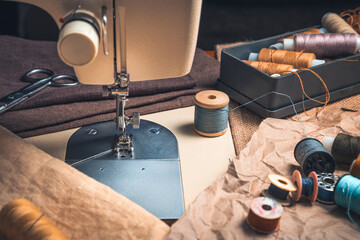 A close-up sewing machine and a set of threads. Side view