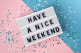 Fototapeta  - Have a nice weekend - text on display lightbox on blue and pink background.