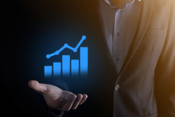 Businessman man holding a graph with positive profits growth. plan graph growth and increase of chart positive indicators in his business.more profitable and growing.