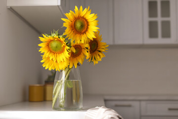 Poster - Vase with beautiful yellow sunflowers in kitchen, space for text