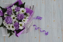 Bouquet Of Flowers On A Wooden Background. The White And Purple Flowers Are Tied With A String Ribbon.