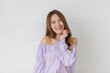 © Bangkok Click Studio - Portrait close up shot of young pretty asian female with long brown hair wearing light purple long sleeve shirt stand smiling to camera putting her right hand up over her chest in front