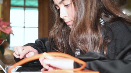 Poster - Young girl using laptop at home. Home schooling and learning concept