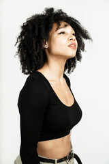 Wall Mural - a woman of Afro appearance poses in a photo studio on a white background. curly-haired brunette in a black short jacket. copy space