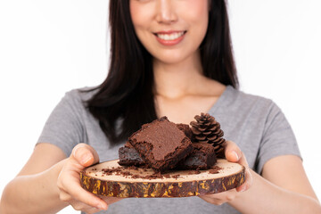 Wall Mural - Asian woman holding brownie cake on wooden plate, feeling happy and good lifestyle isolated on white background. Beautiful smiling girl holding and eating chocolate isolated on white background.